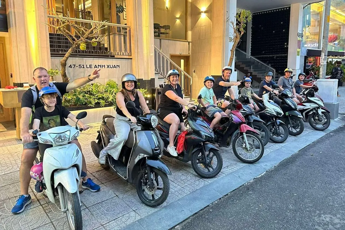 A family with kids posing on the scooters before the food tour
