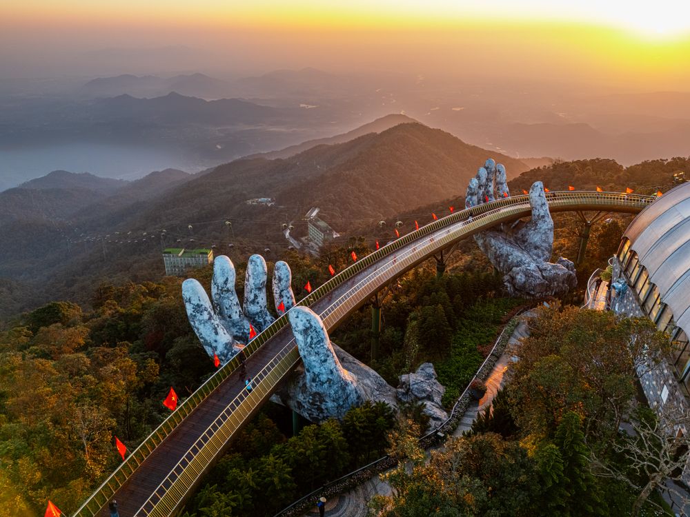 Aerial view of the iconic Golden Bridge at Ba Na Hills during sunset