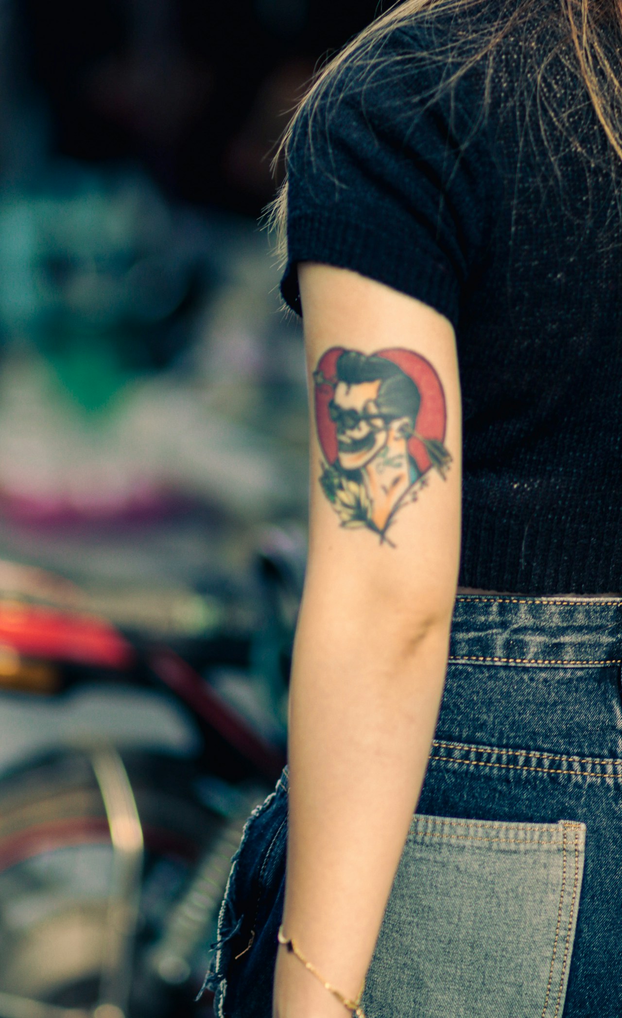 Woman in Hanoi showing arm tattoo outdoors