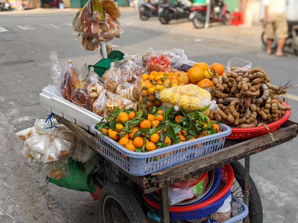 Colorful street food cart at Dong Ba Market in Hue, Vietnam with fresh fruit and tamarind