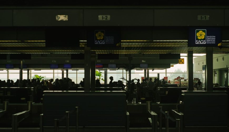 Saigon Tan Son Nhat airport check-in counter with travelers and Vietnam Airlines aircraft silhouette