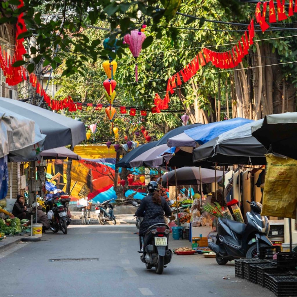 Street market in Vietnam with food stalls and motorbikes