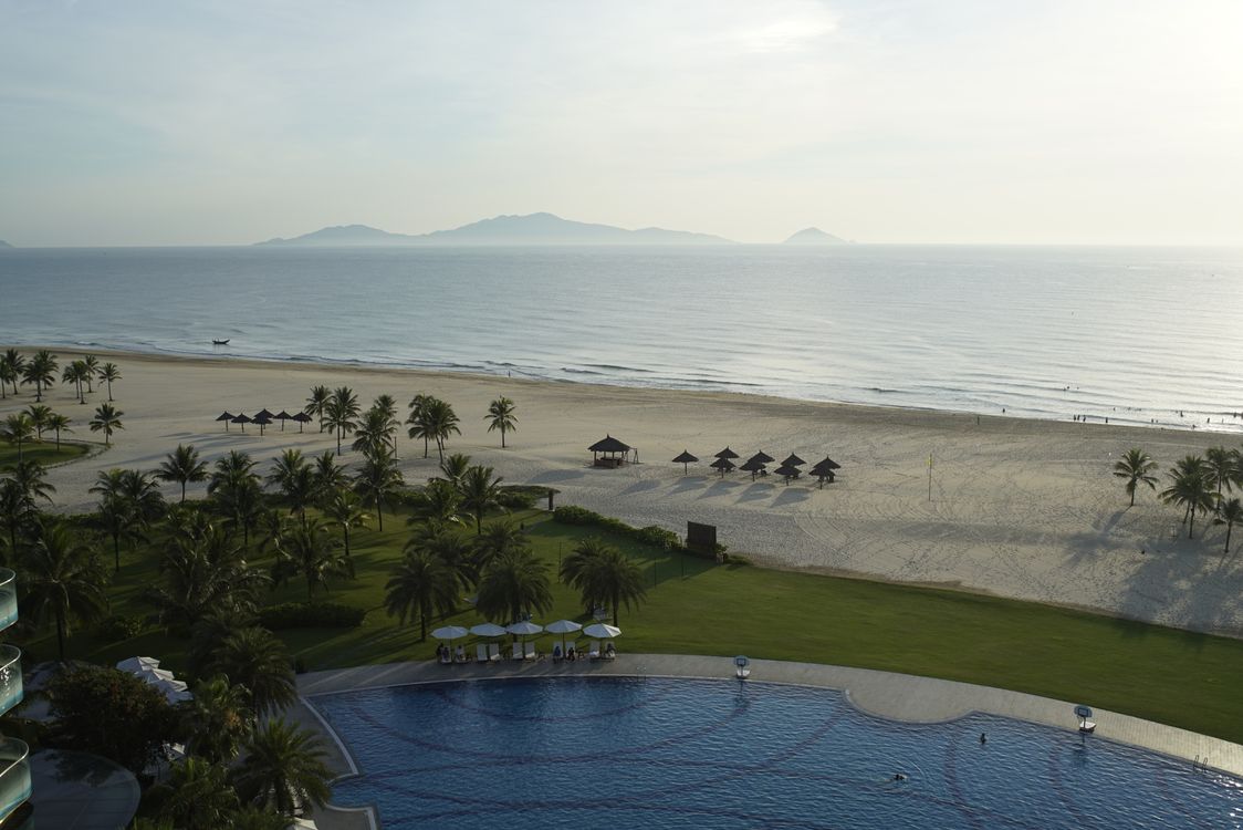 Aerial view of beachfront resort with pool and palm trees