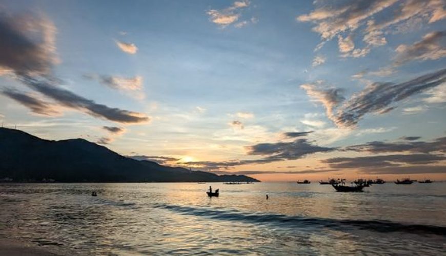 Golden sunrise over Da Nang beach with calm waves and colorful sky
