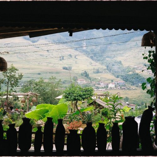 Lush green Sapa rice terraces in summer with misty mountains in the background