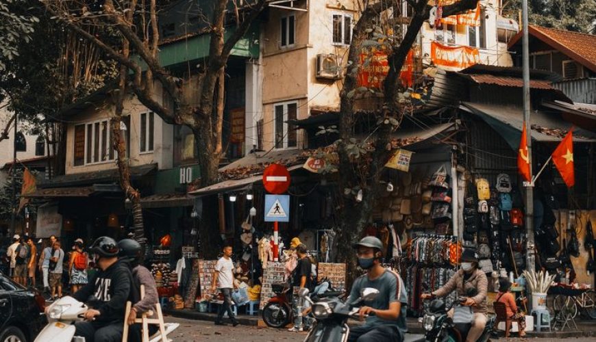 Busy street scene in Hanoi Old Quarter with scooters, shops and local life