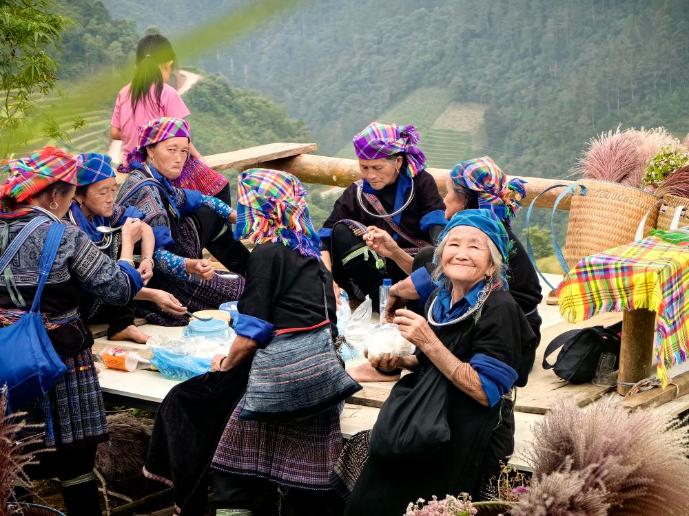 Hmong women in traditional attire gathering in a Vietnamese mountain village