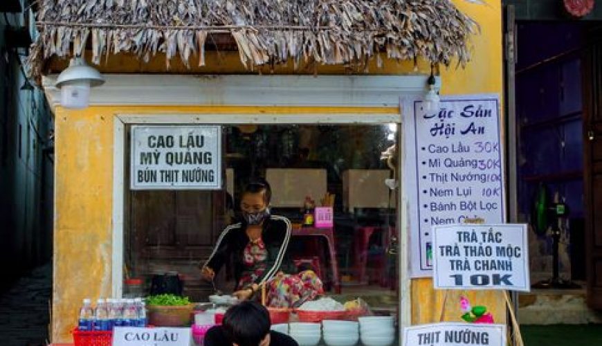 Street food vendor cooking at a night market in Hoi An, Vietnam