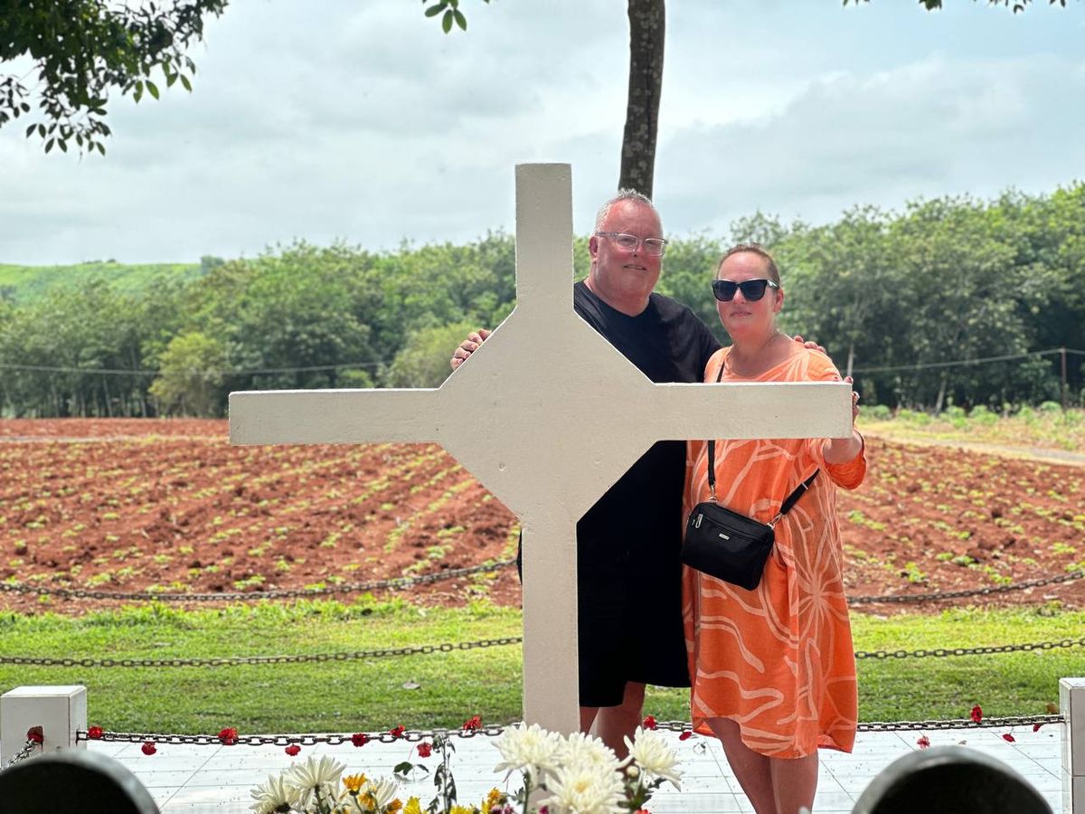 White memorial monument at Long Tan battlefield, red soil fields of Nui Dat