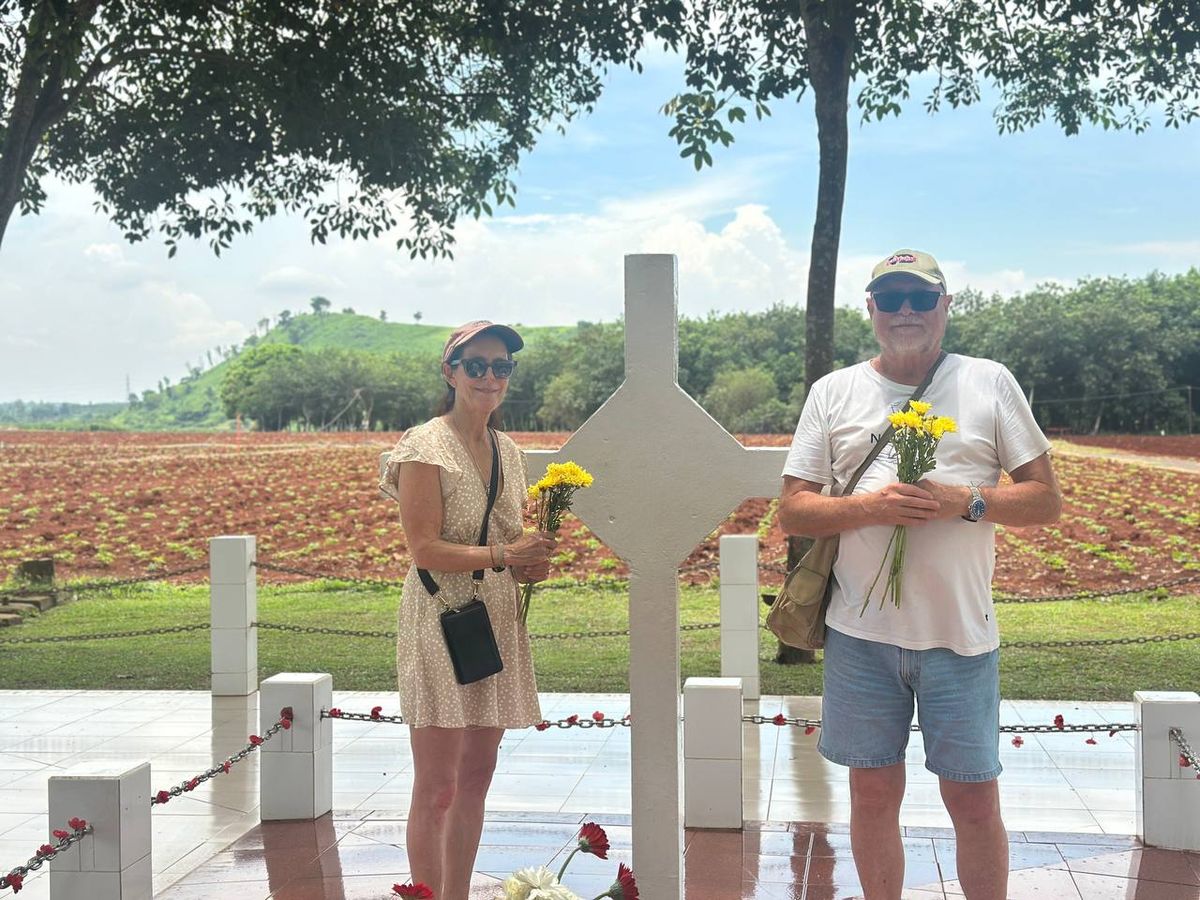 Australian couple paying respects at the Long Tan Cross with yellow flowers
