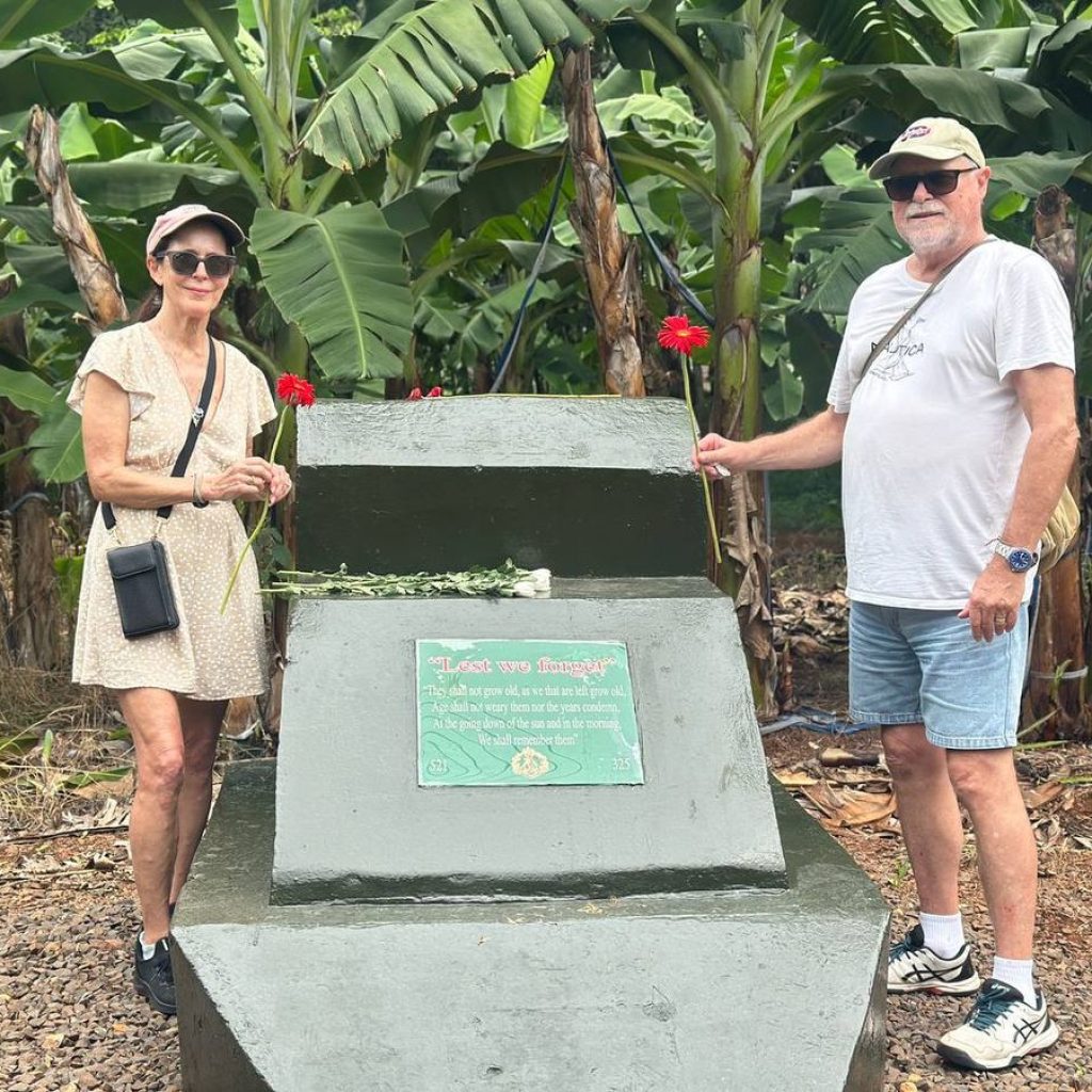Australian couple standing beside the Long Tan memorial plaque in a banana plantation, Vietnam