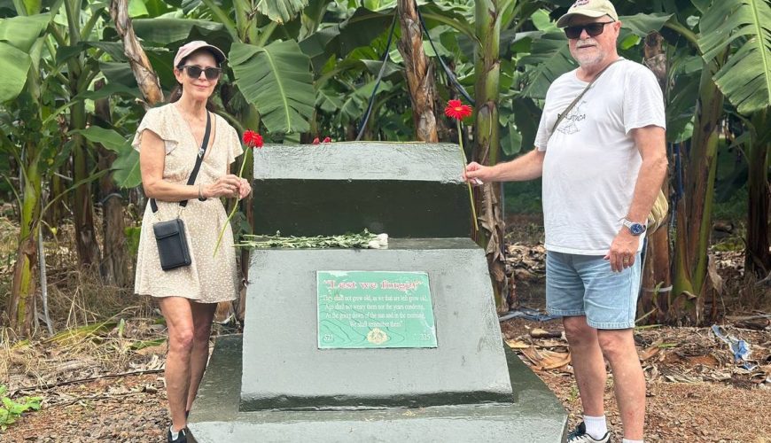 Australian couple standing beside the Long Tan memorial plaque in a banana plantation, Vietnam