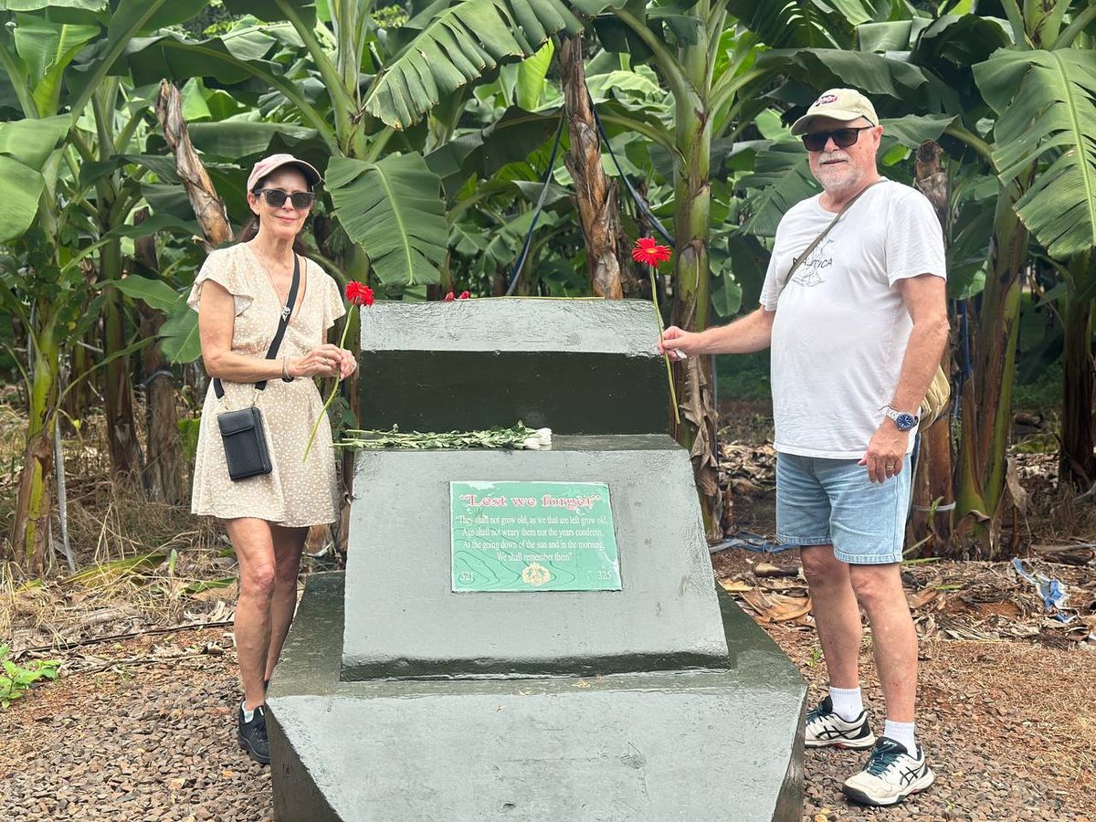 Australian couple standing beside the Long Tan memorial plaque in a banana plantation, Vietnam