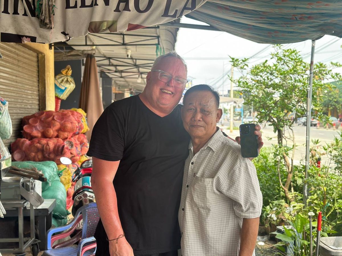 Australian traveler taking a selfie with a local guide in Vietnam market