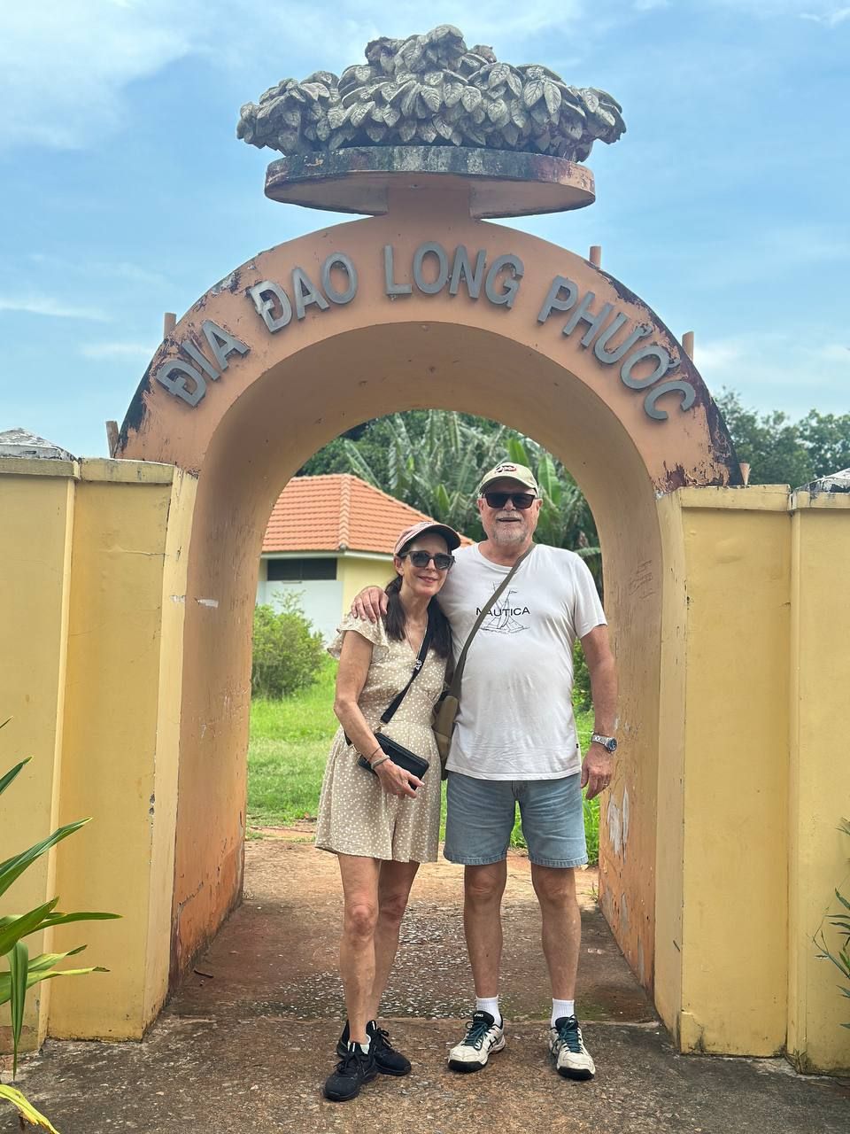 Australian couple at the entrance arch of Địa Đạo Long Phước tunnels