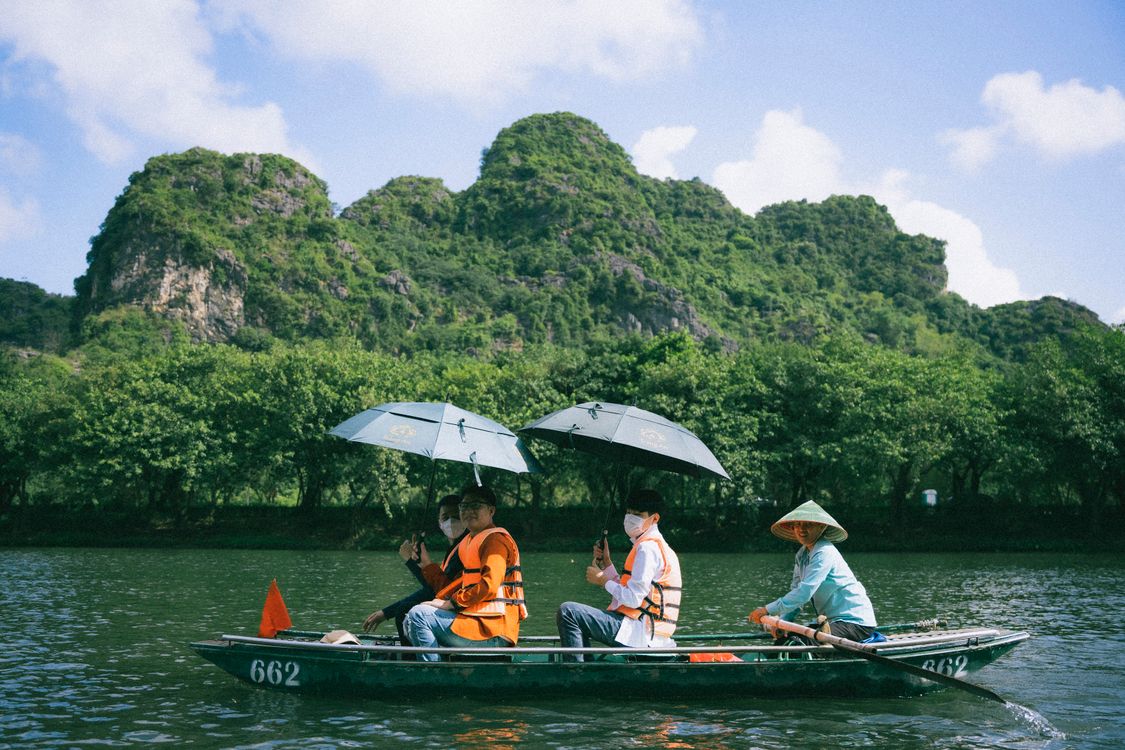 Tourists on a scenic boat ride through lush greenery in Ninh Binh, Vietnam