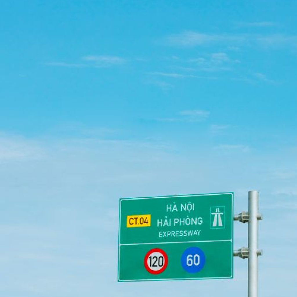 Expressway road sign against clear blue sky on a Vietnamese highway