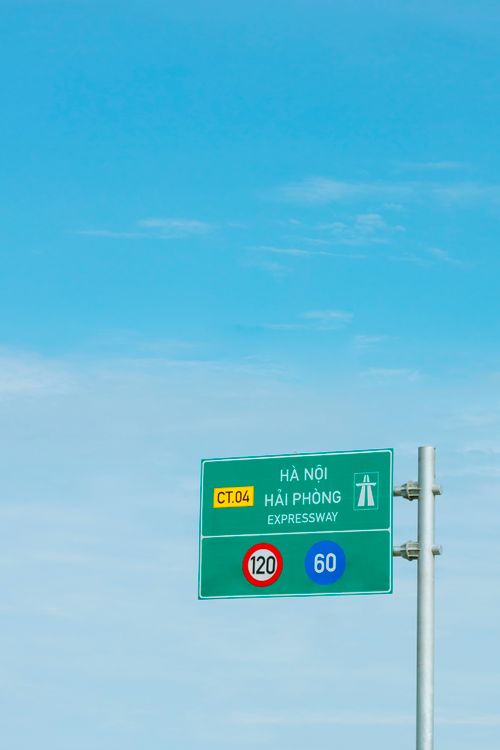 Expressway road sign against clear blue sky on a Vietnamese highway