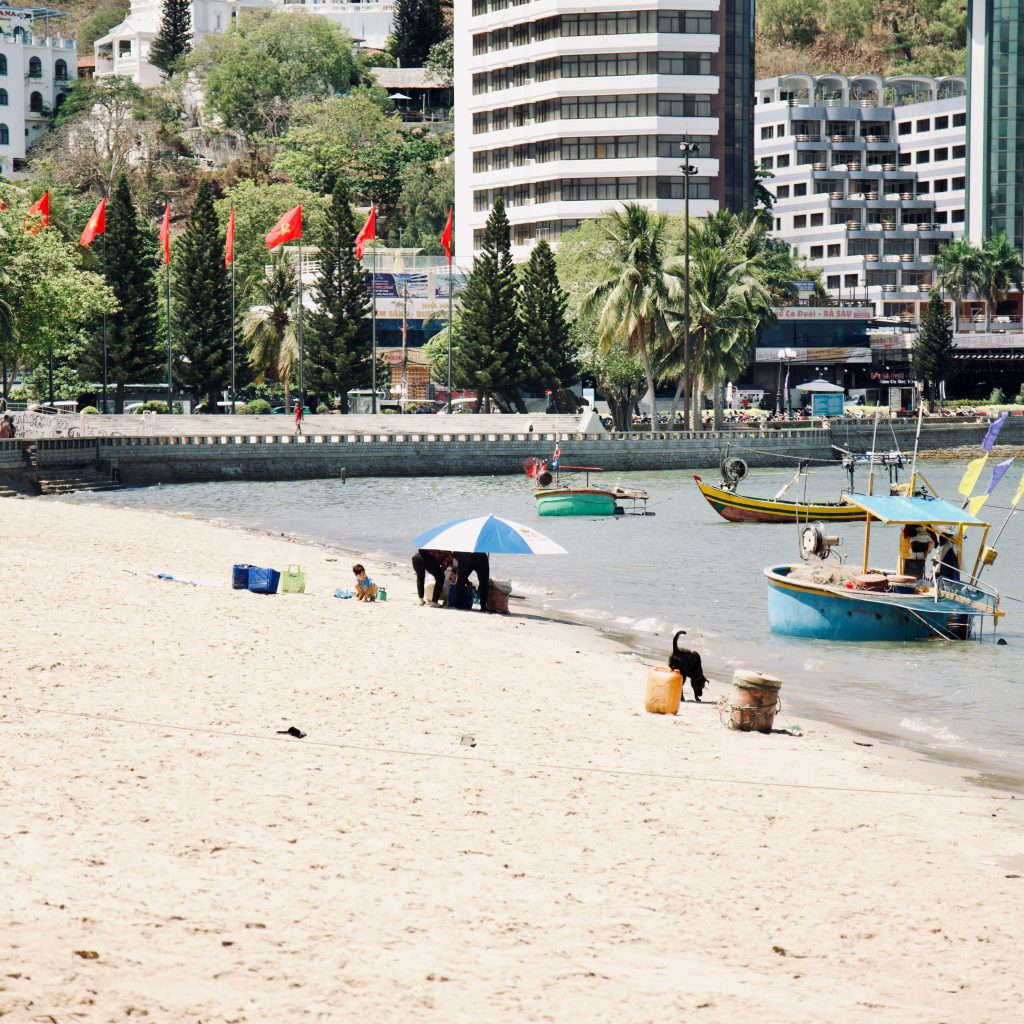 Busy beach scene with boats docked and city skyline in Vung Tau