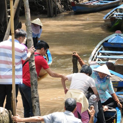 Sampan boat ride through palm-shaded canals in Ben Tre, Mekong Delta