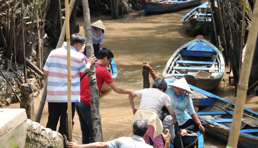 Sampan boat ride through palm-shaded canals in Ben Tre, Mekong Delta