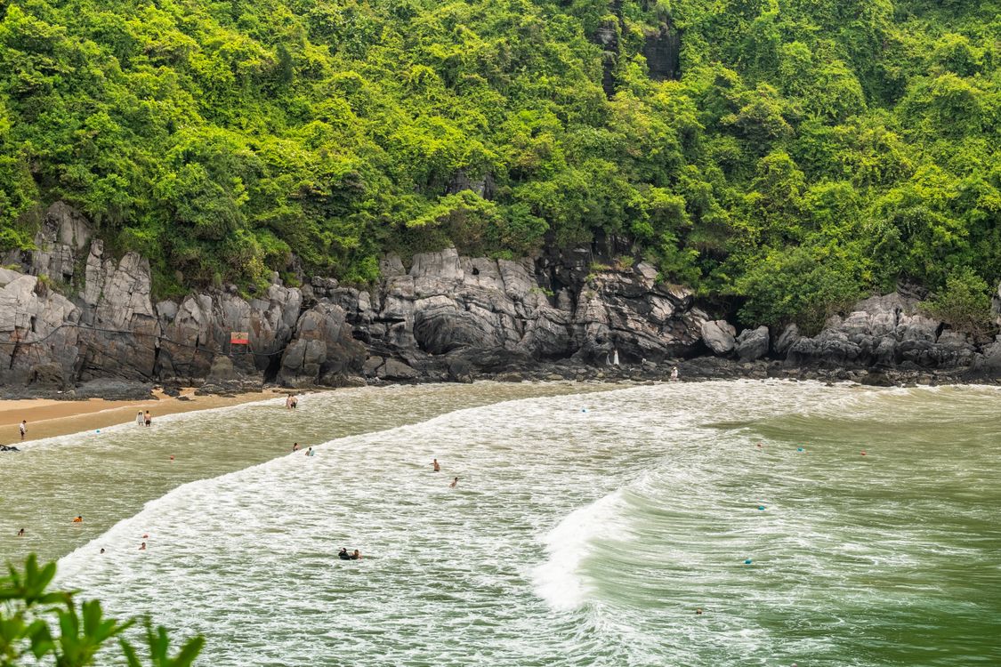 People swimming at a small beach on Cat Ba Island in Vietnam