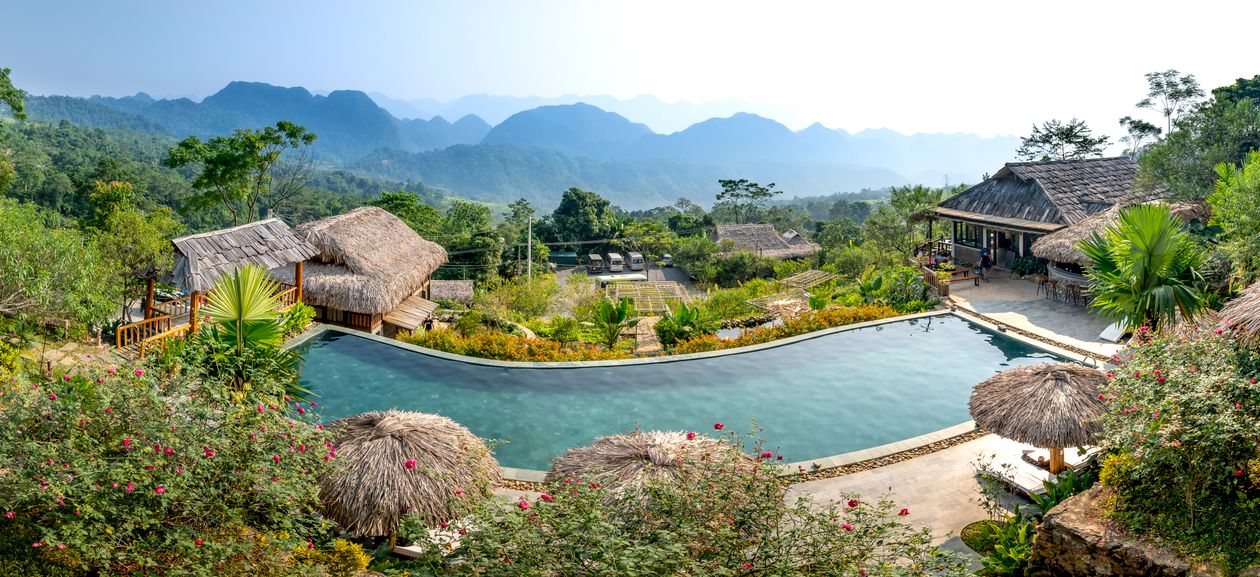 Swimming pool at a beach resort in Da Nang with sunbeds and palm trees