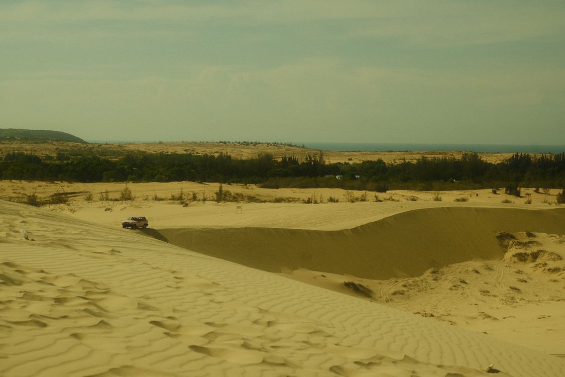 Sand dunes of Mui Ne, Vietnam — the desert-like landscape with a vehicle driving across