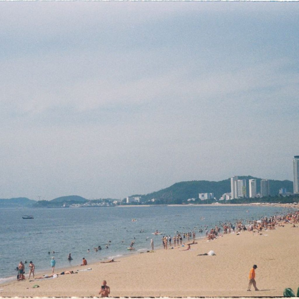 Summer day at Nha Trang Beach, Vietnam — the long city beach packed with people in the sun