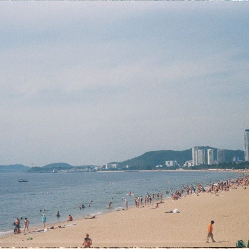 Summer day at Nha Trang Beach, Vietnam — the long city beach packed with people in the sun