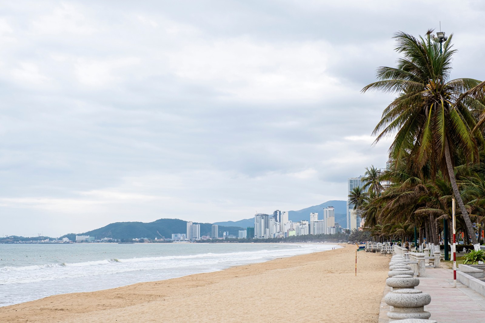 Nha Trang beach beside palm trees and a seafront walkway