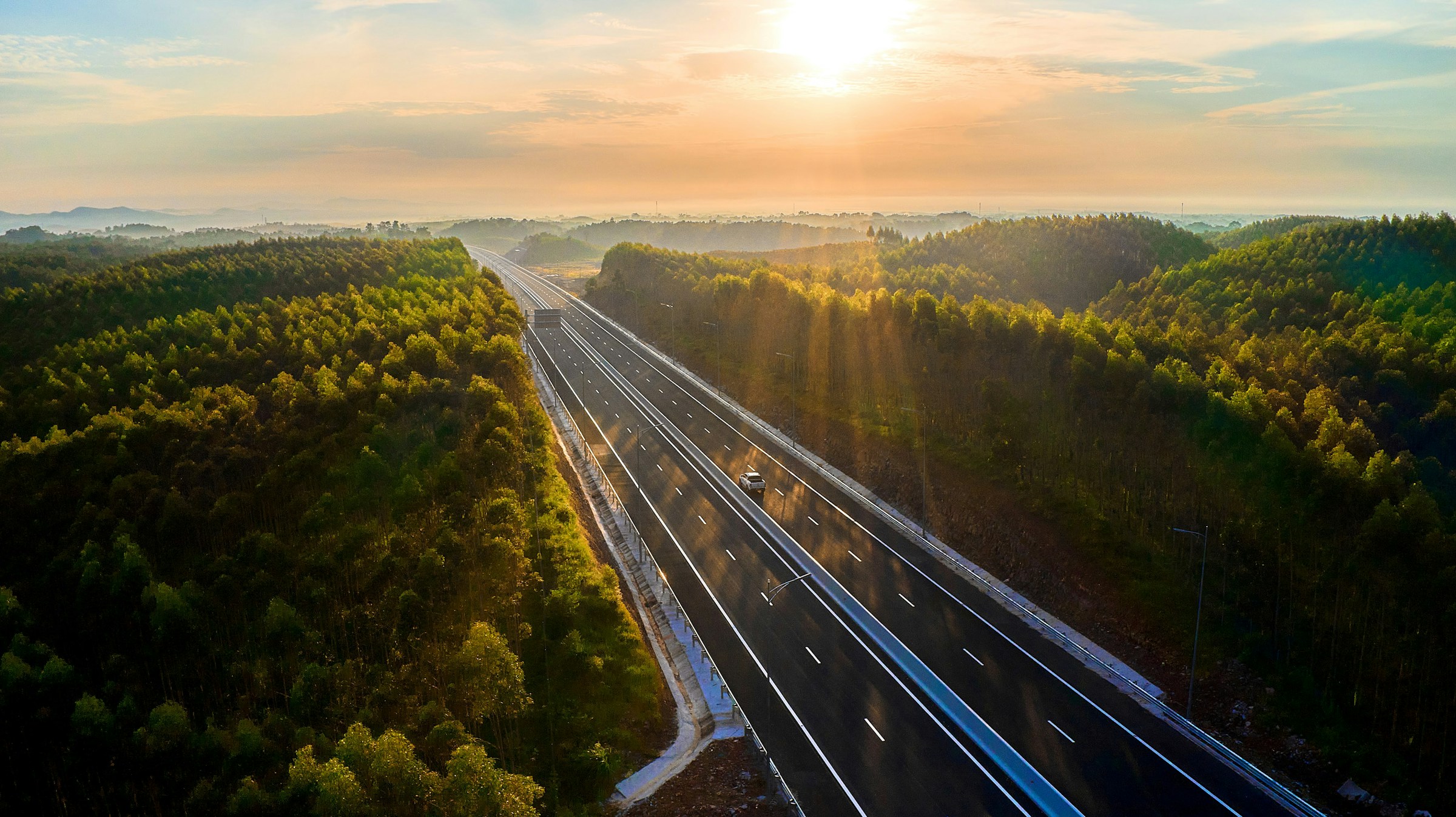 A divided expressway running through forested hills in Quang Ninh, Vietnam