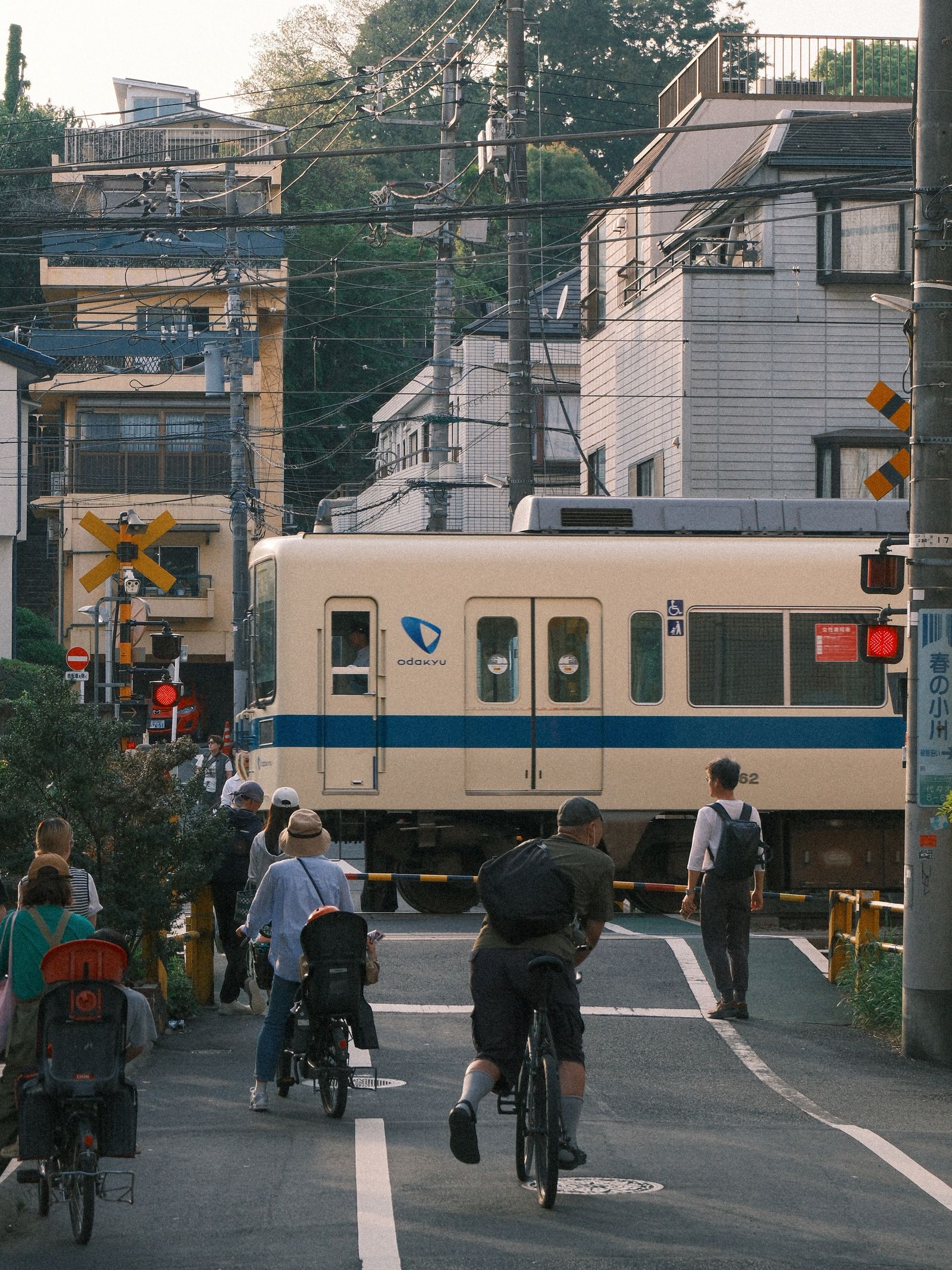 Pedestrians and cyclists waiting at a railway crossing in Tokyo