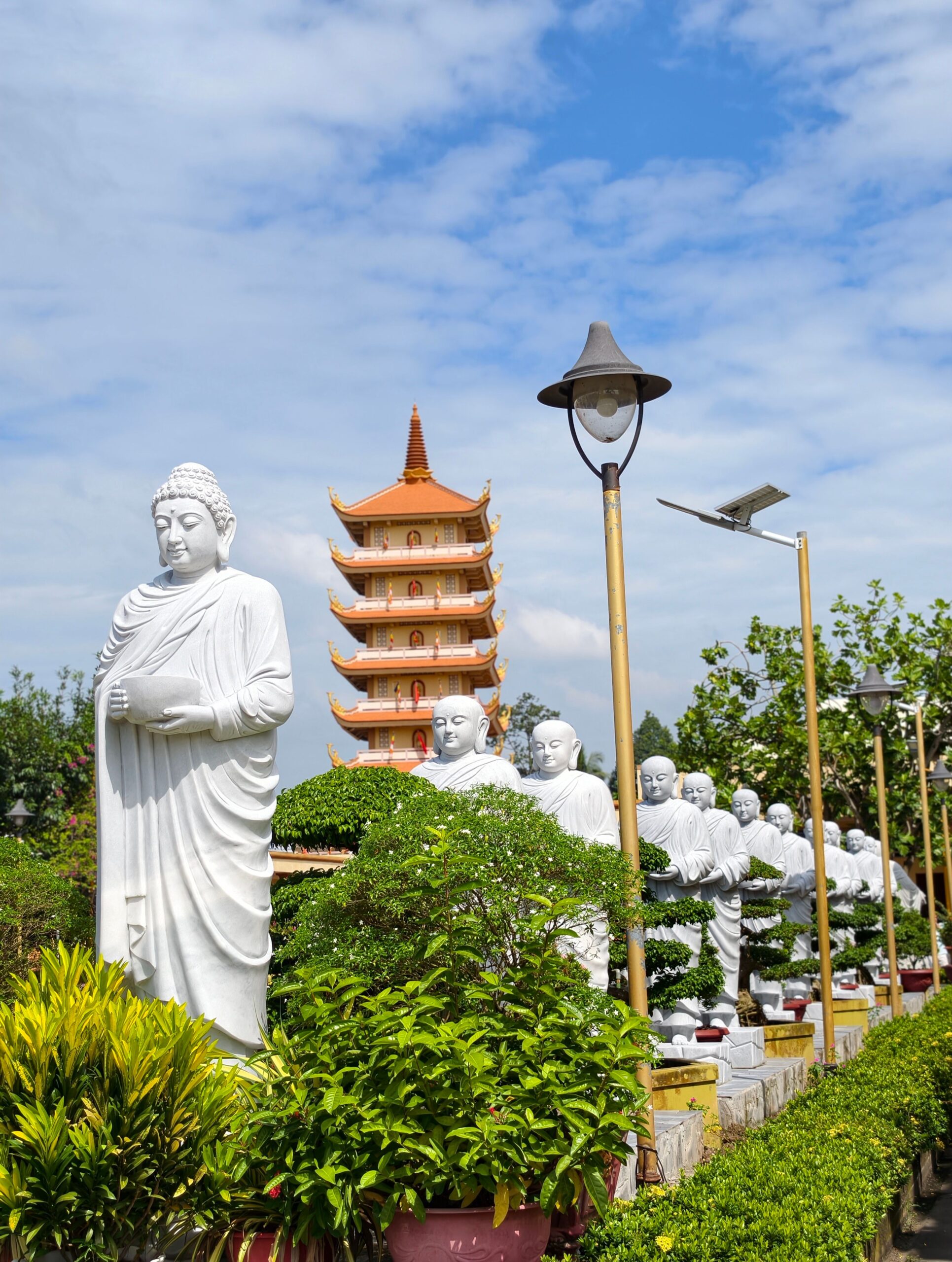 Buddha statues and a pagoda tower at a Vietnamese Buddhist temple