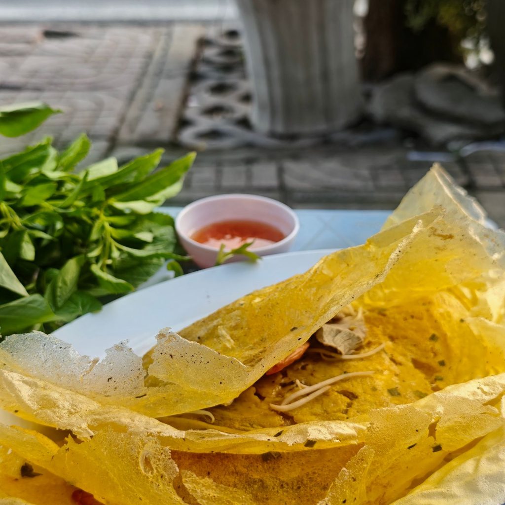 Crispy Vietnamese bánh xèo served with fresh herbs and dipping sauce
