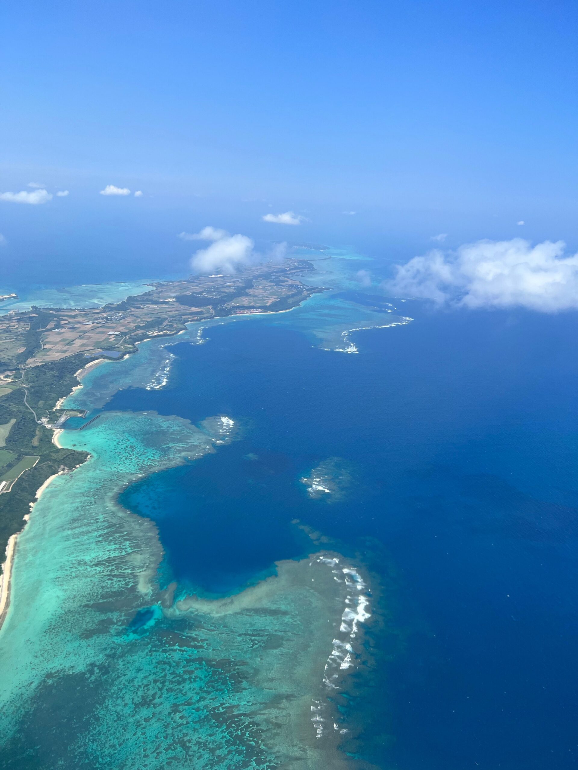 Aerial view of Okinawa’s turquoise sea, reef and coastal landscape.