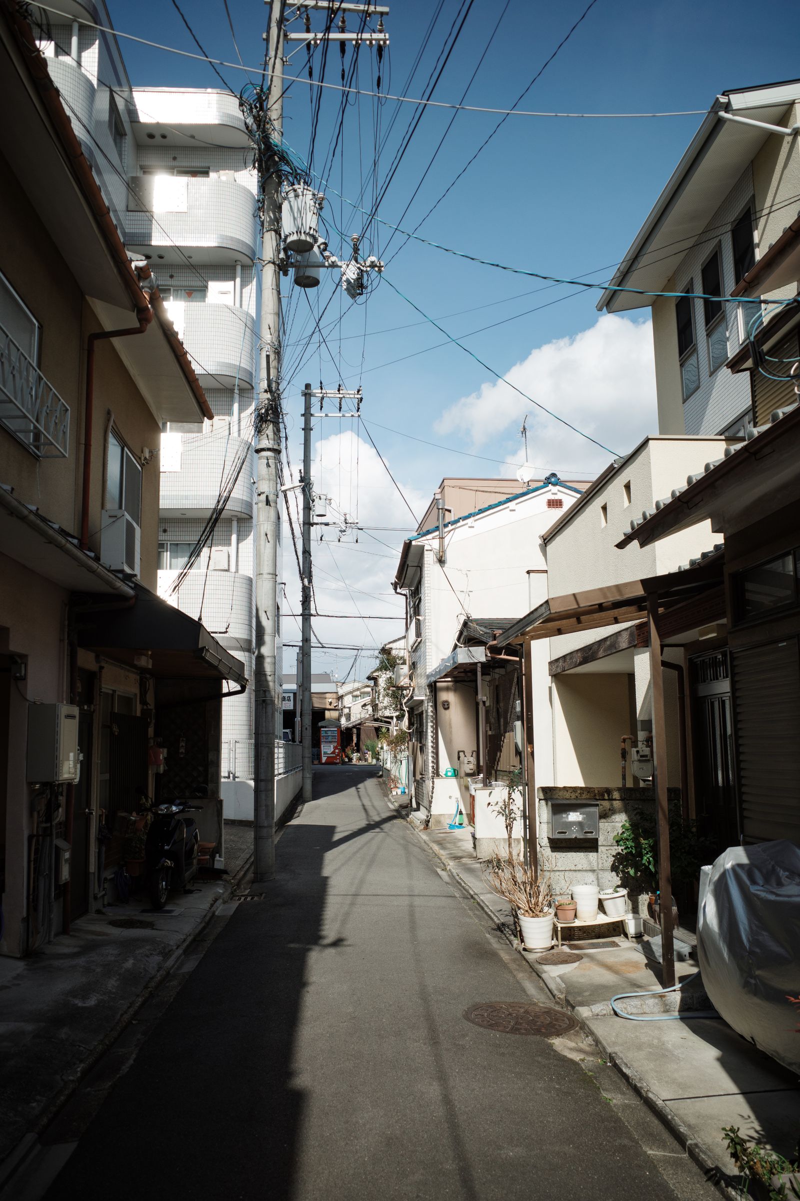 A residential street with traditional houses and parked bicycles in Kyoto