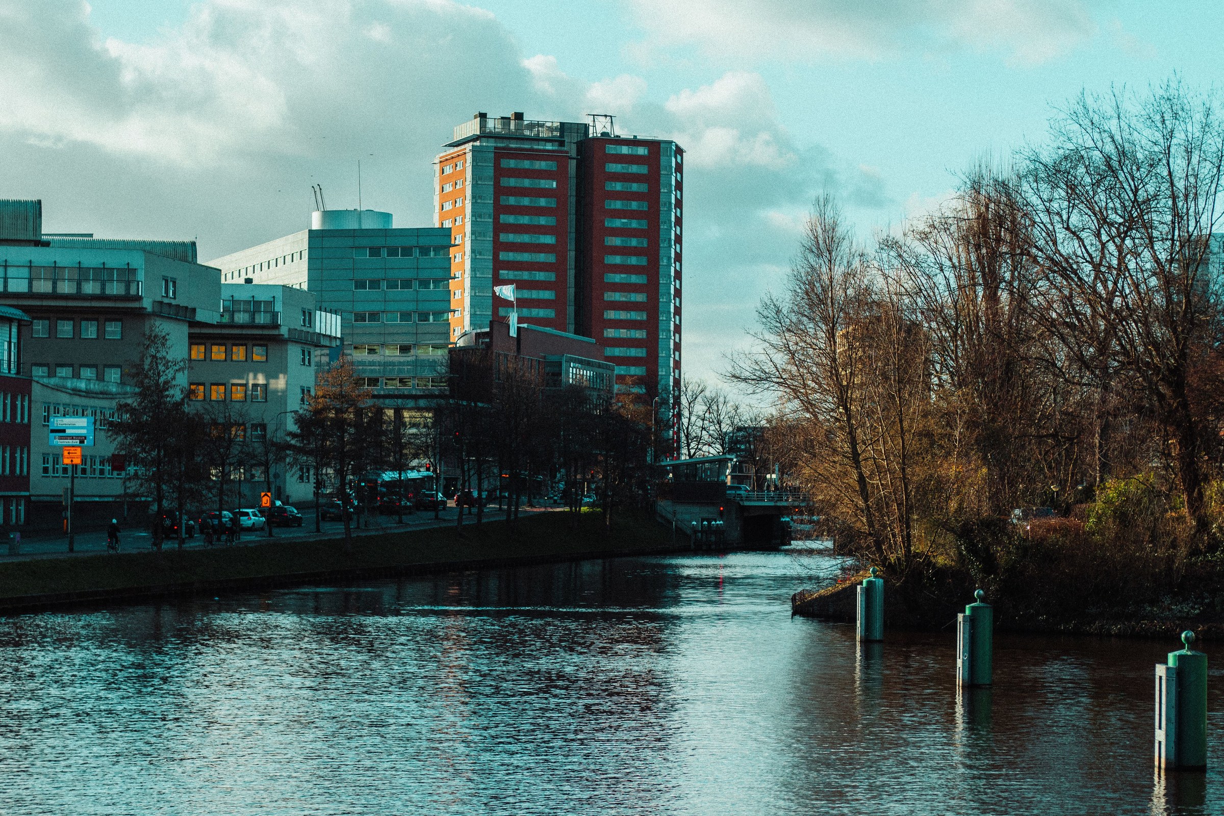 A waterway, modern buildings and trees in Groningen.