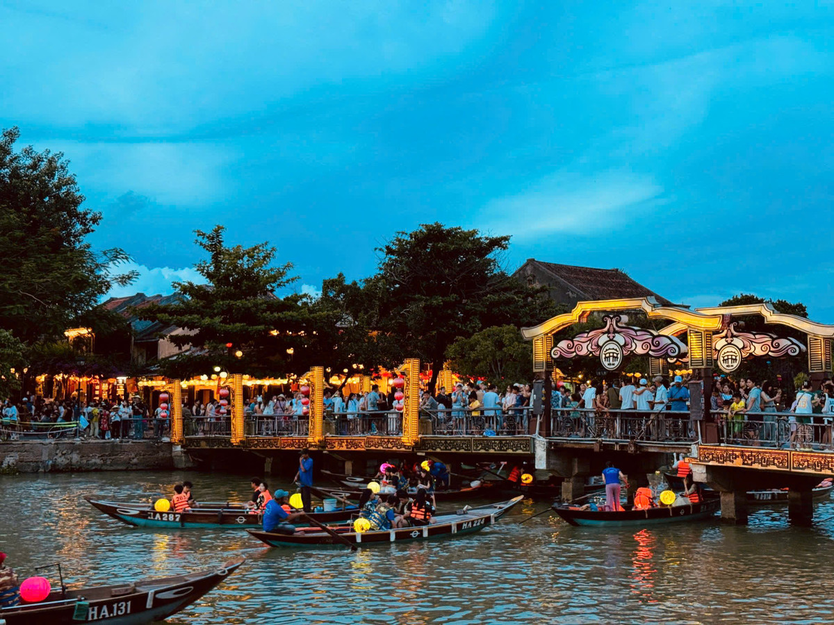 Lantern-lit boats and the illuminated bridge in Hoi An