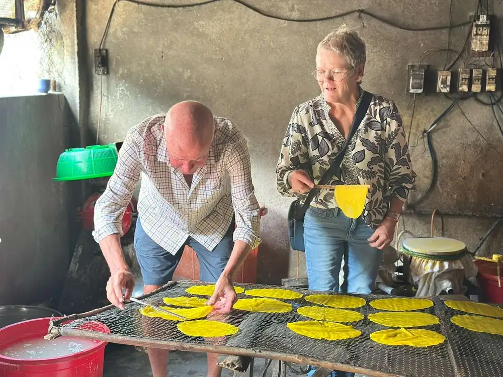 A local family drying rice paper sheets in Hue