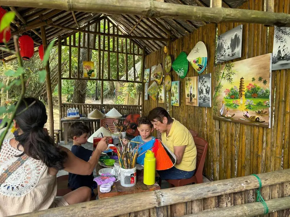 Painting conical hats at the lakeside souvenir workshop in Hue