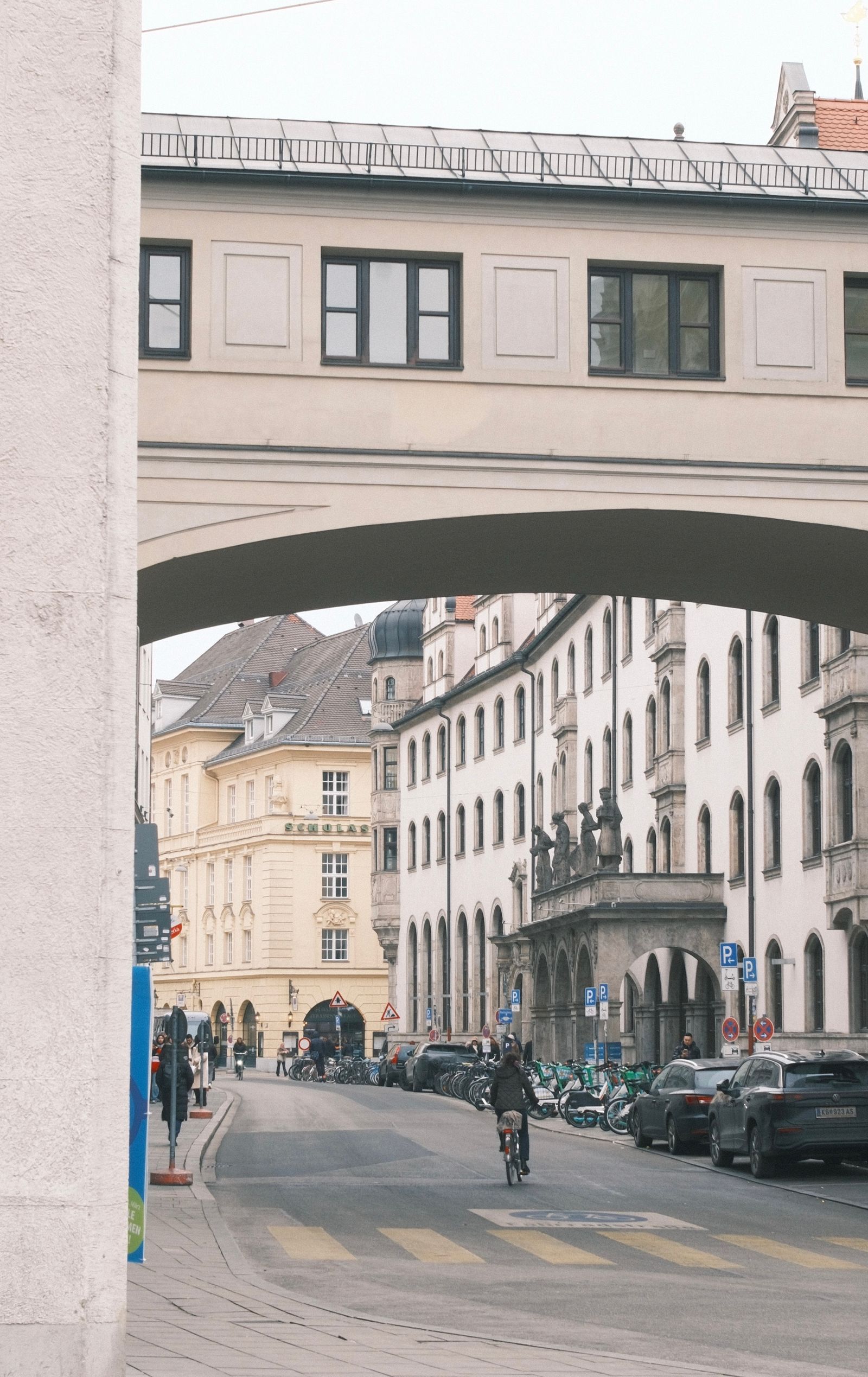 Munich street with historic facades beneath an architectural arch