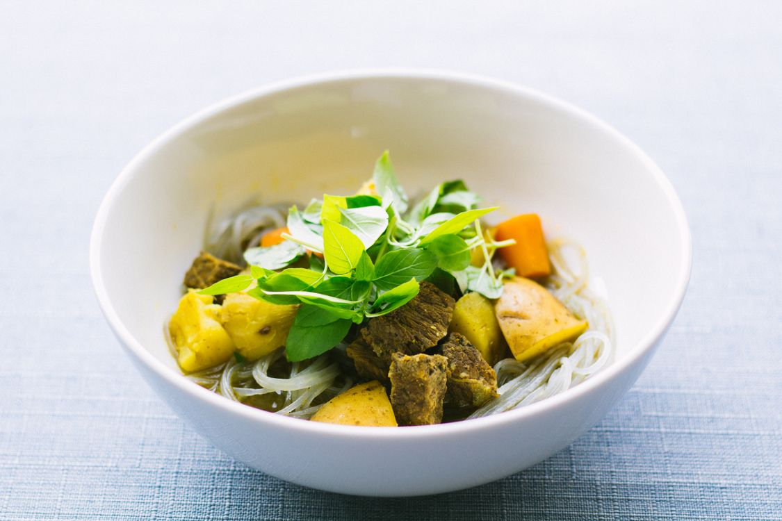 Bowl of Vietnamese-style rice noodles with fresh herbs and vegetables.