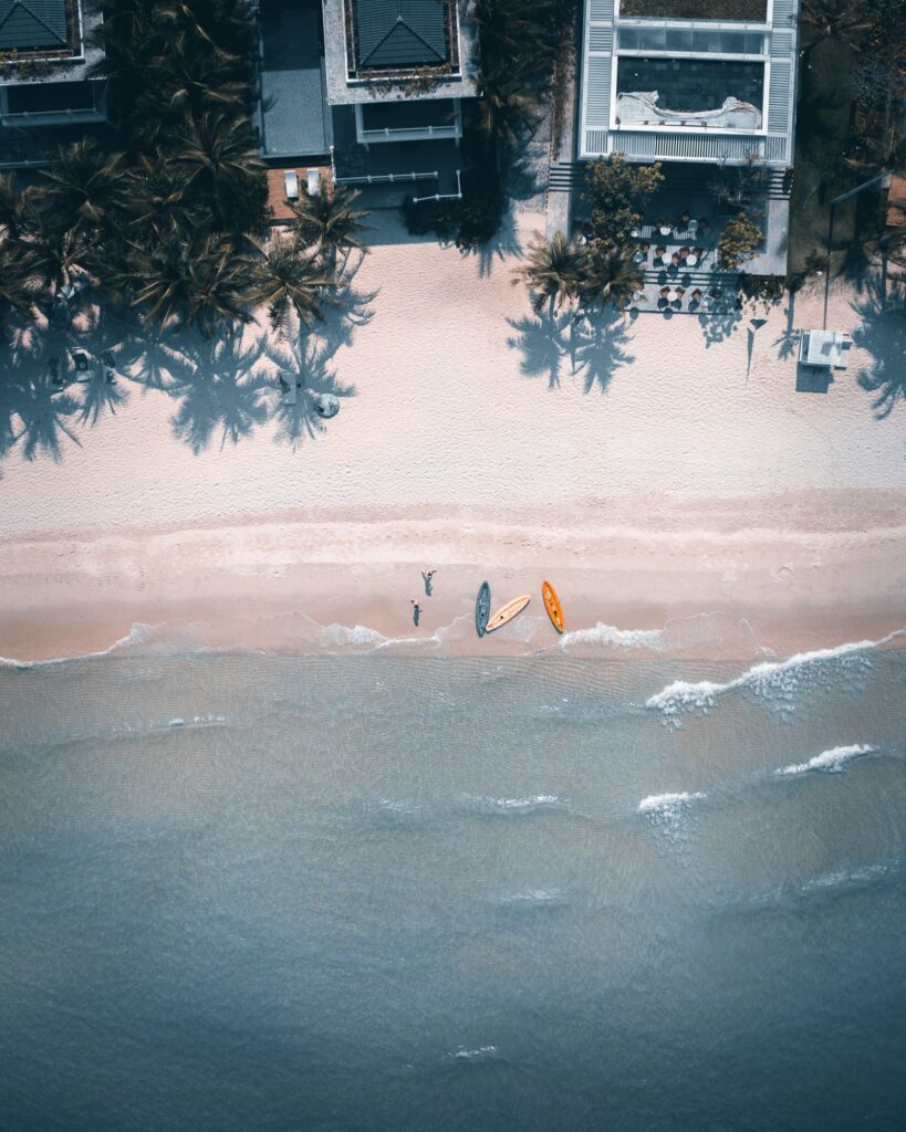 Aerial view of a Phu Quoc beach coastline with kayaks and palm-fringed shore