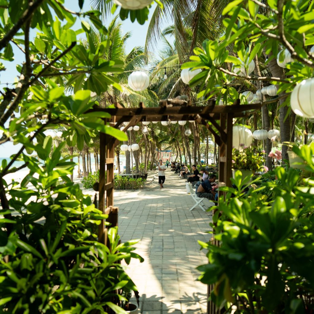 Tropical walkway leading toward a sandy beach in Da Nang