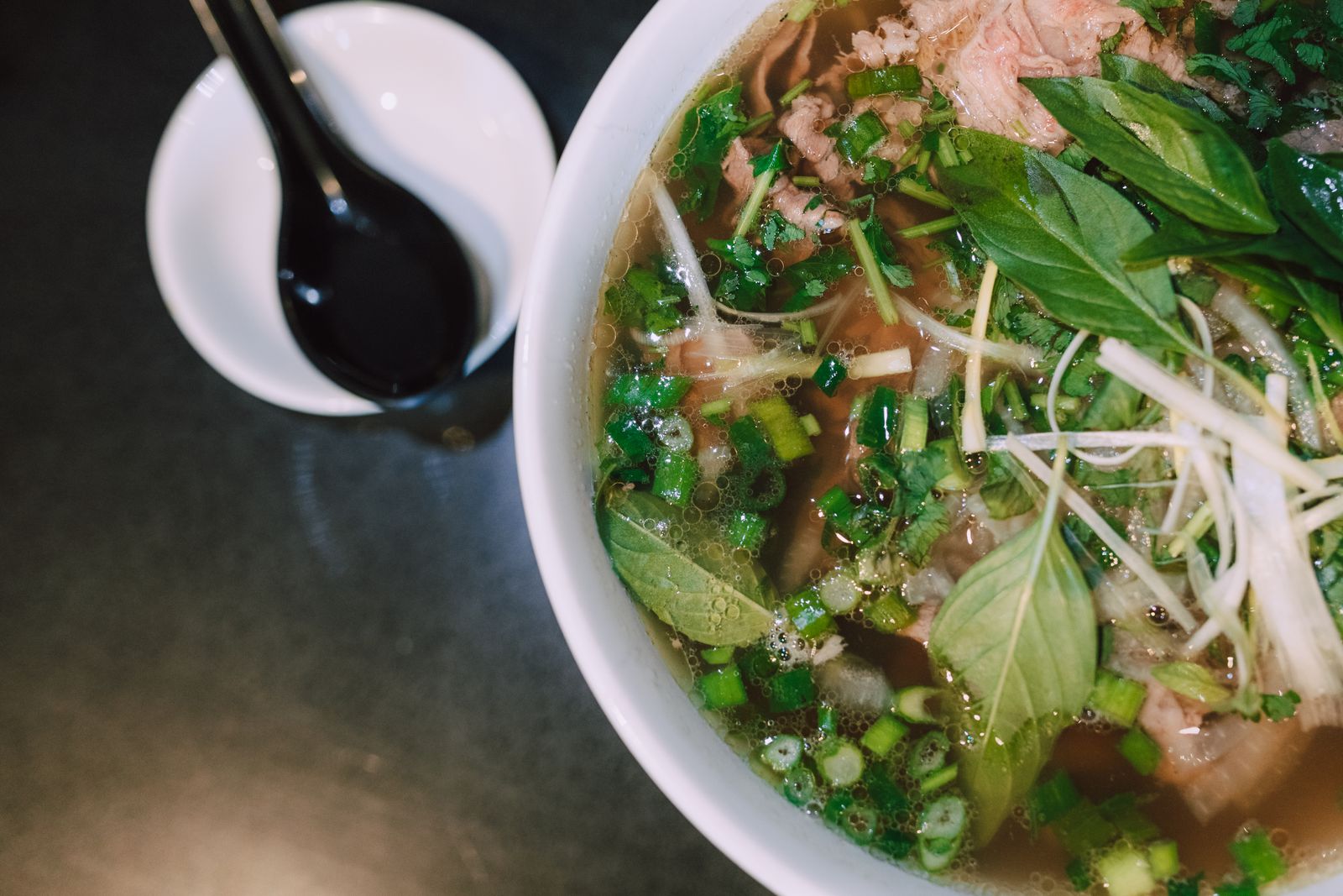 Vietnamese noodle soup with sliced meat and fresh herbs