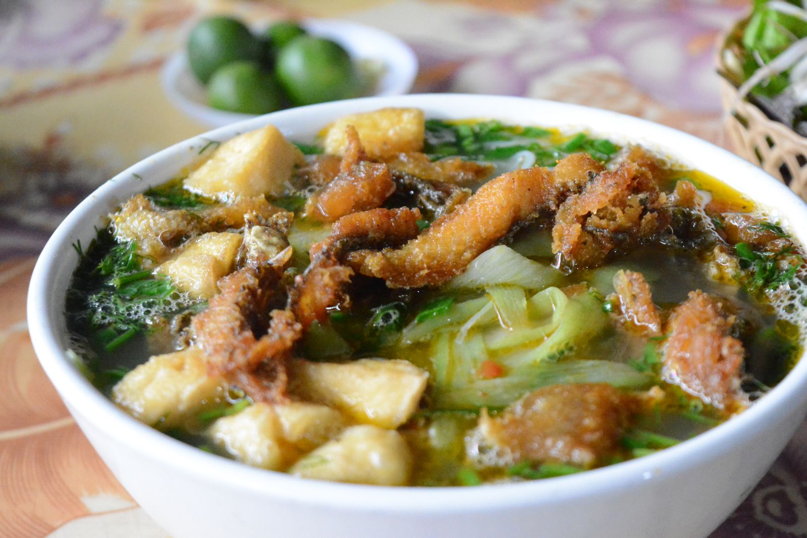 Bowl of bun ca Vietnamese fish noodle soup with fried fish, tofu and dill