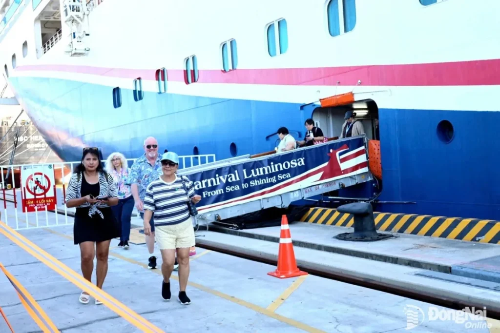 Cruise passengers walk down the gangway from the Carnival Luminosa.