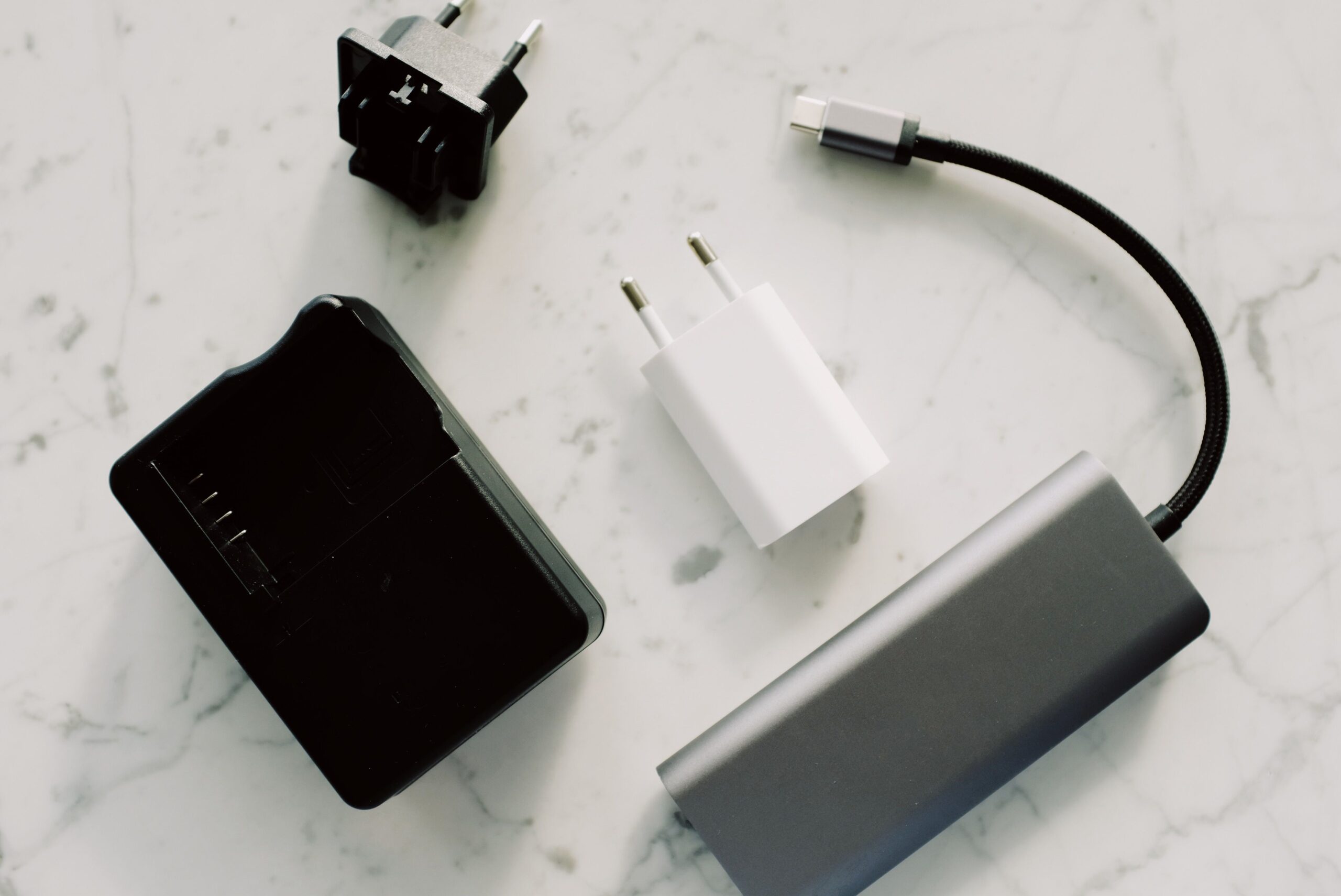 Electronic adapters and cables on marble Electronic adapters, a white USB charger and cables arranged on a marble surface