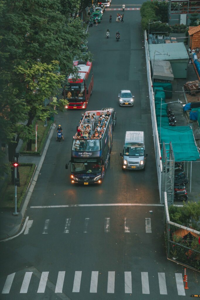 A city bus and a passenger bus traveling along an urban street